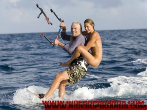 richard branson kiteboarding with a nude bikini babe on his back